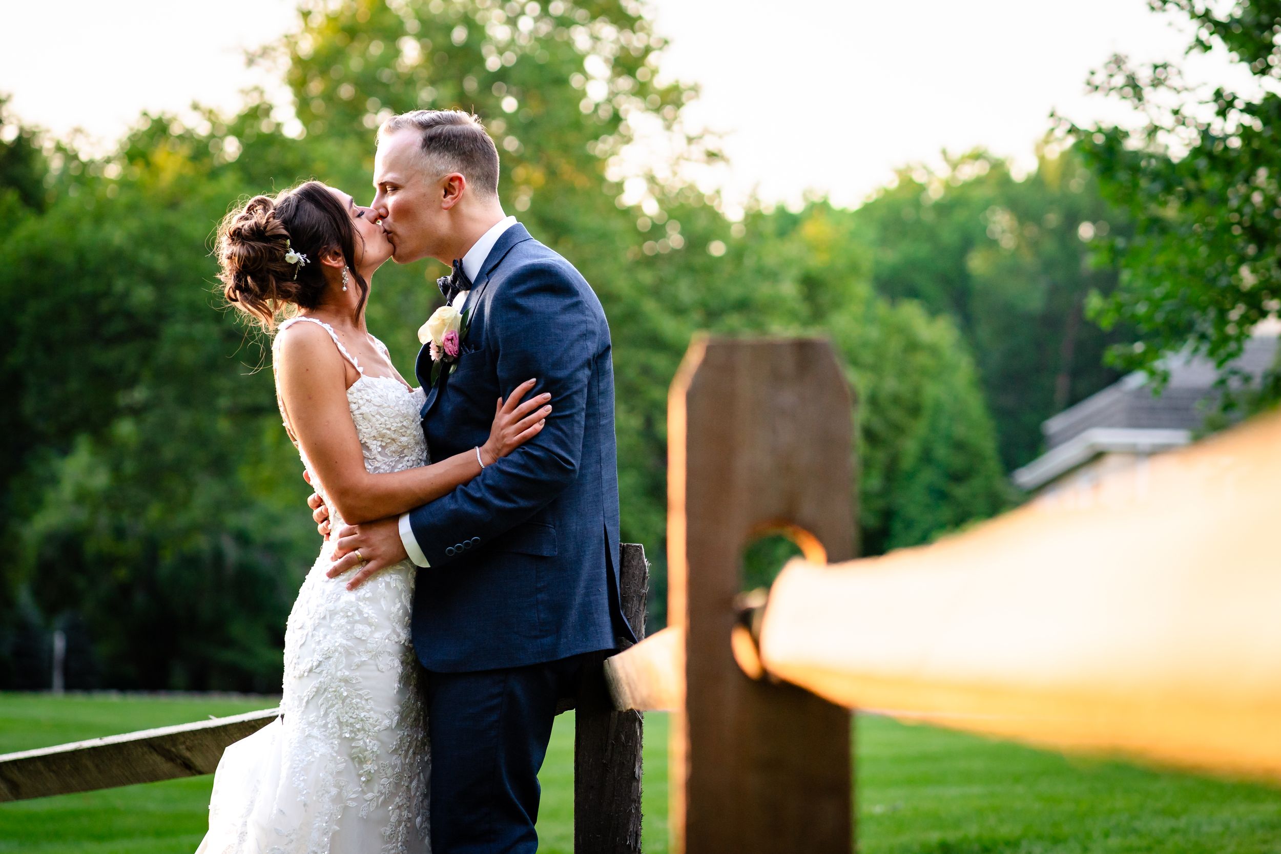 Romantic wedding portraits captured against lush green outdoor garden backdrop.