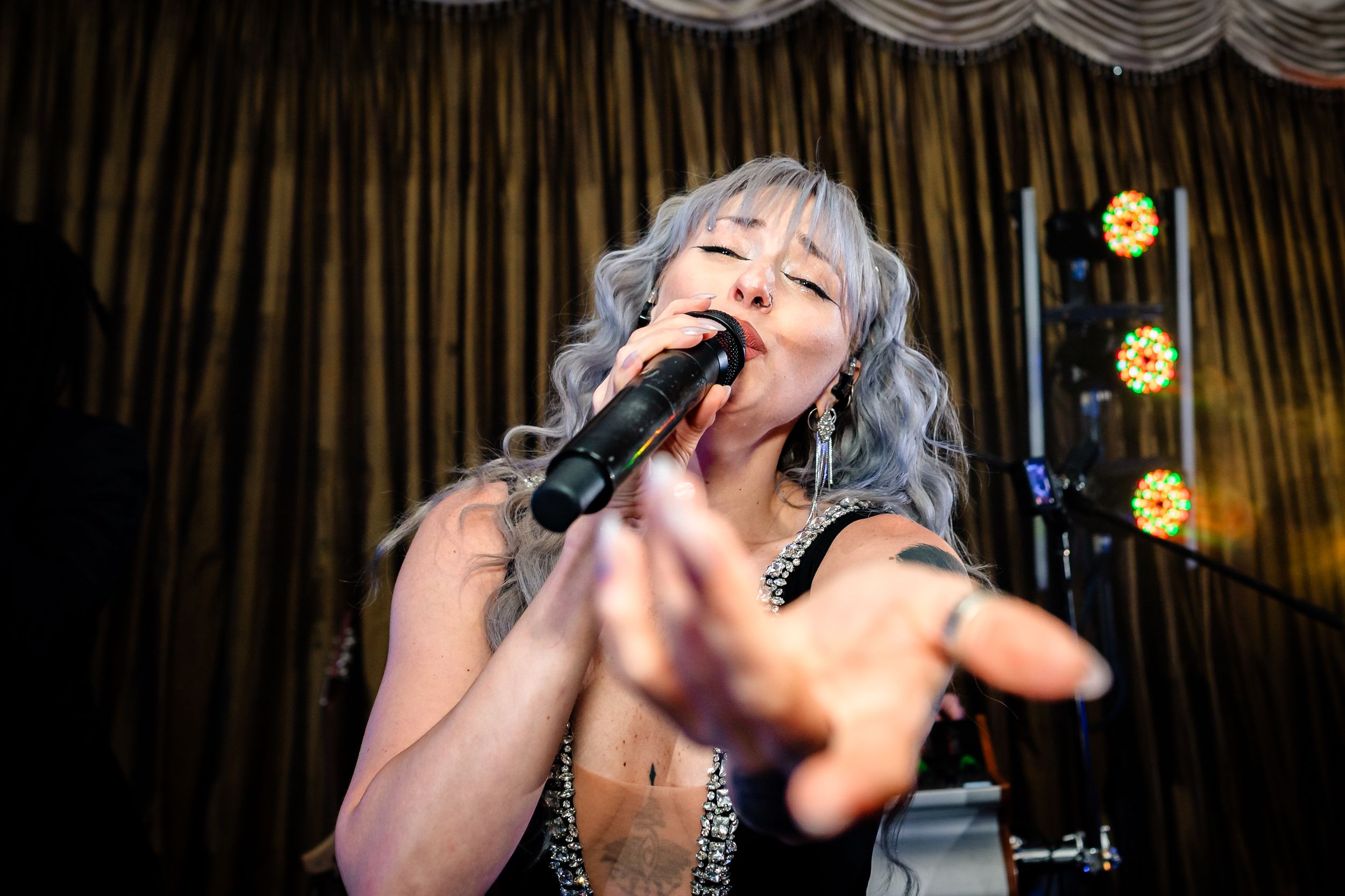 Live band performs energetically on stage at wedding reception.
