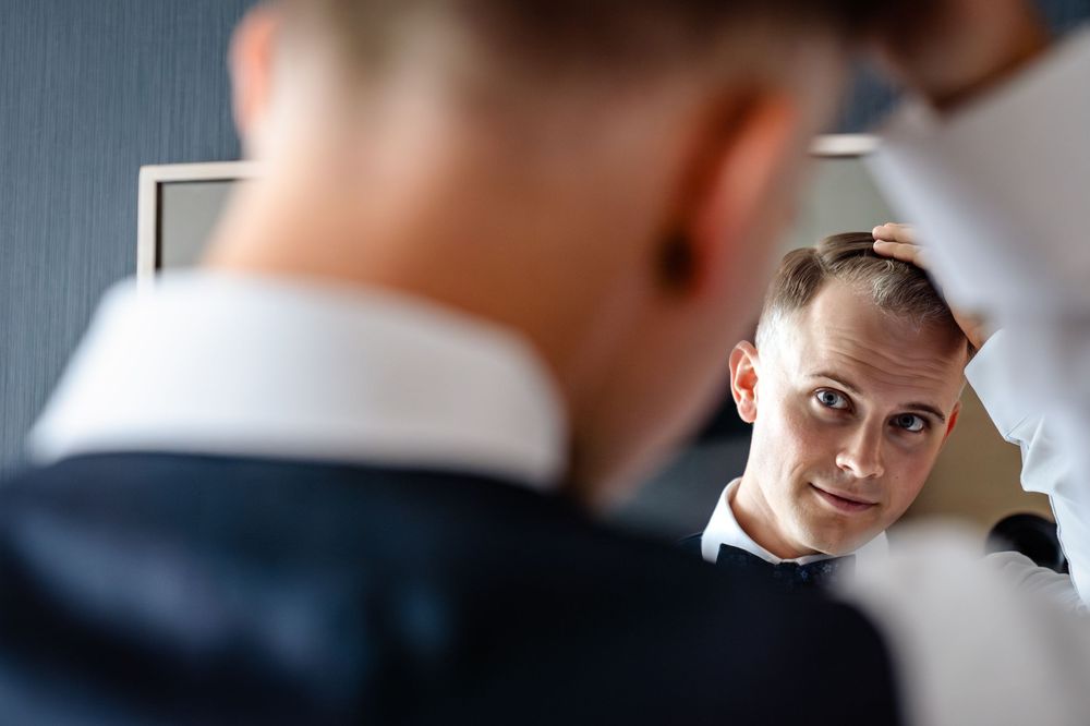 Wedding preparation reflection showing formal attire in mirror.