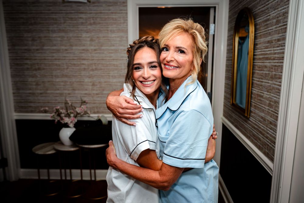 Two people in matching light blue outfits embracing during celebration.