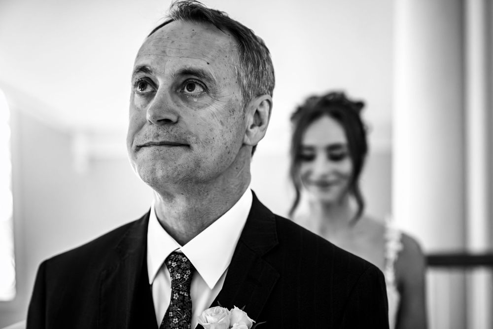 A black and white candid moment captured during a wedding ceremony.