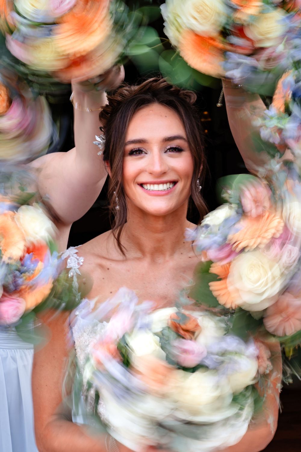 Creative motion blur photo of bridal party with soft pastel flowers.
