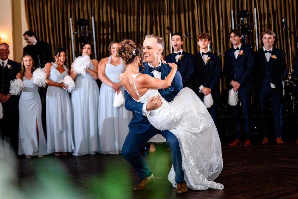 Wedding reception dance floor filled with guests in formal attire celebrating the newlyweds.