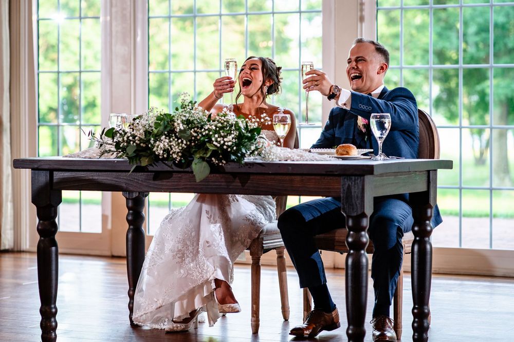 Wedding reception guests share laughter and joy during celebrations in a sunlit venue.