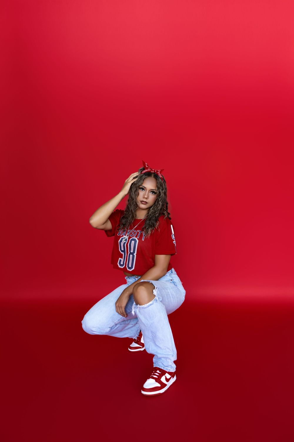 Athletic figure in red jersey and white skirt poses expressively against vibrant red background in varied positions.