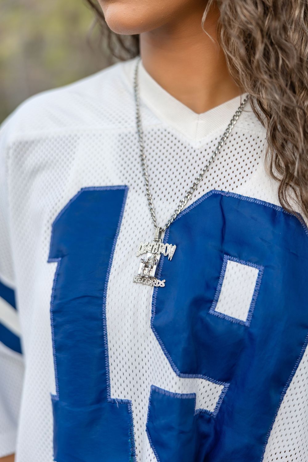 Close-up sequence showing white mesh sports jersey with blue number being placed and adjusted on torso.