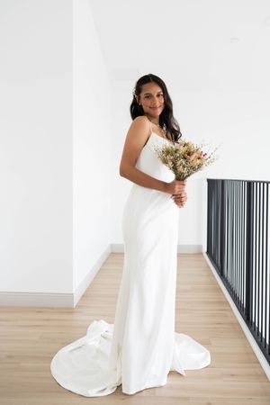 Wedding scene with elegant white dress and dried floral bouquet.