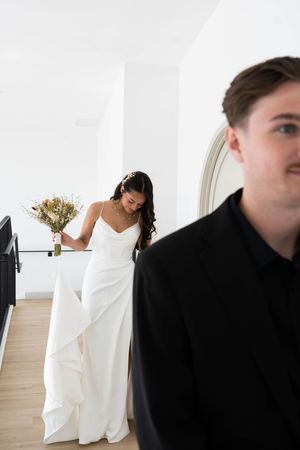 A couple in contrasting black and white formal wear share a candid moment.
