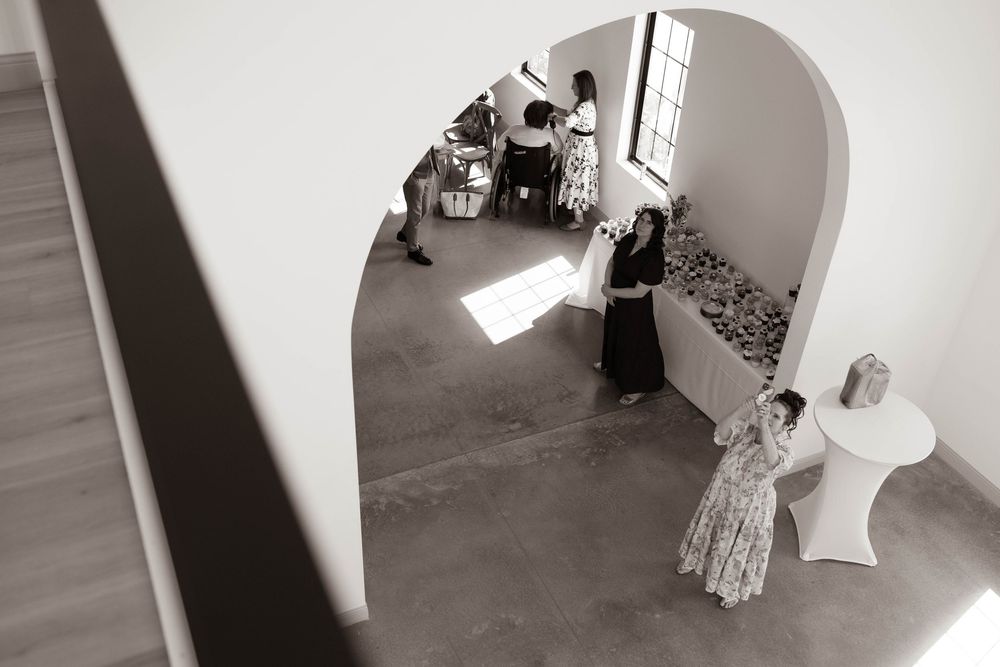 Black and white photo of wedding preparations through an arched doorway.
