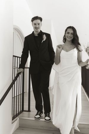 Joyful sequence of newlyweds ascending stairs together in black and white.