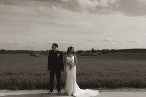 A panoramic black and white wedding photo capturing a couple in a vast countryside setting.