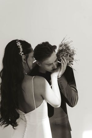 An intimate moment between newlyweds with a dried flower bouquet in black and white.