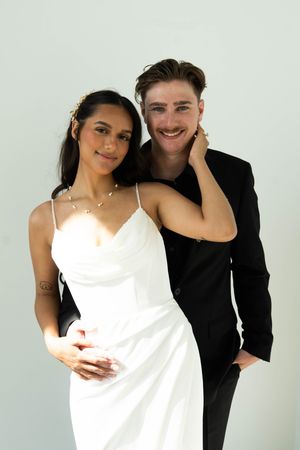 A studio portrait of a couple in contrasting black and white formal attire.