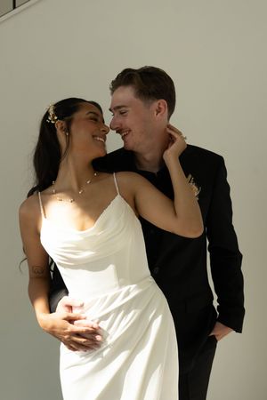 A romantic portrait of a couple in wedding attire sharing an intimate moment in natural light.