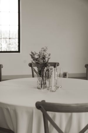 Simple table settings with white linens and delicate floral centerpieces.