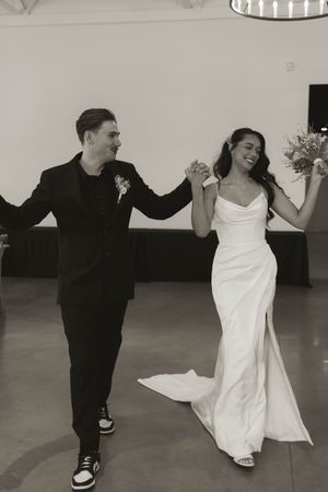 Couple dancing playfully in black and white formal attire.