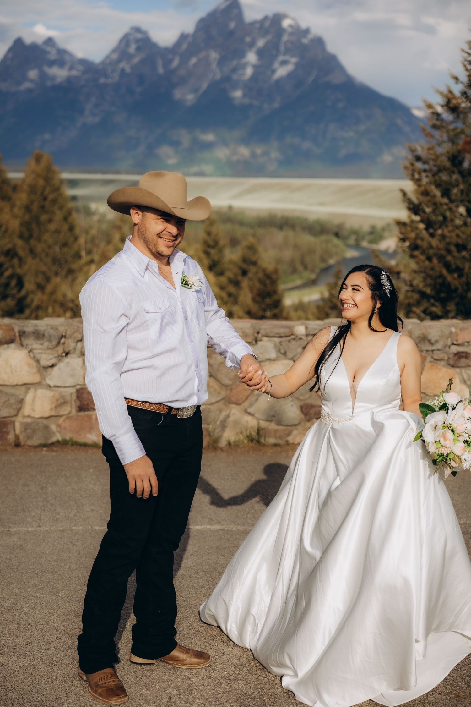 A couple shares joyful moments during their mountain wedding photoshoot, showing playful dance moves against Grand Teton peaks.