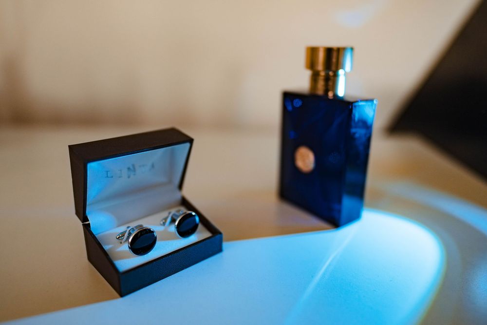 Close-up of wedding rings in blue decorative box with dramatic lighting.