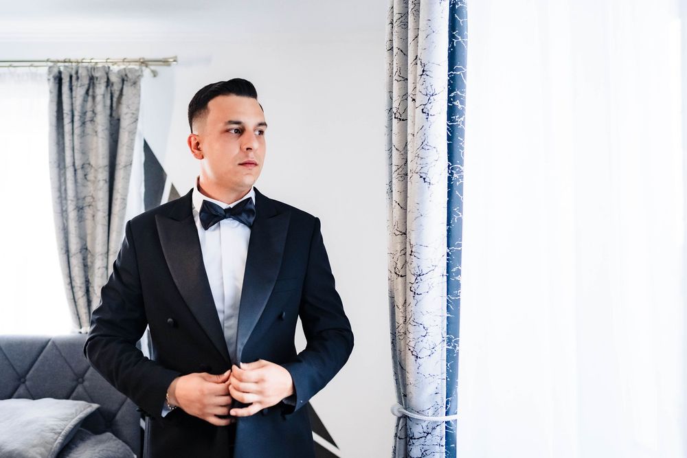 Multiple views of a person in a black tuxedo and bow tie making final adjustments before an event.