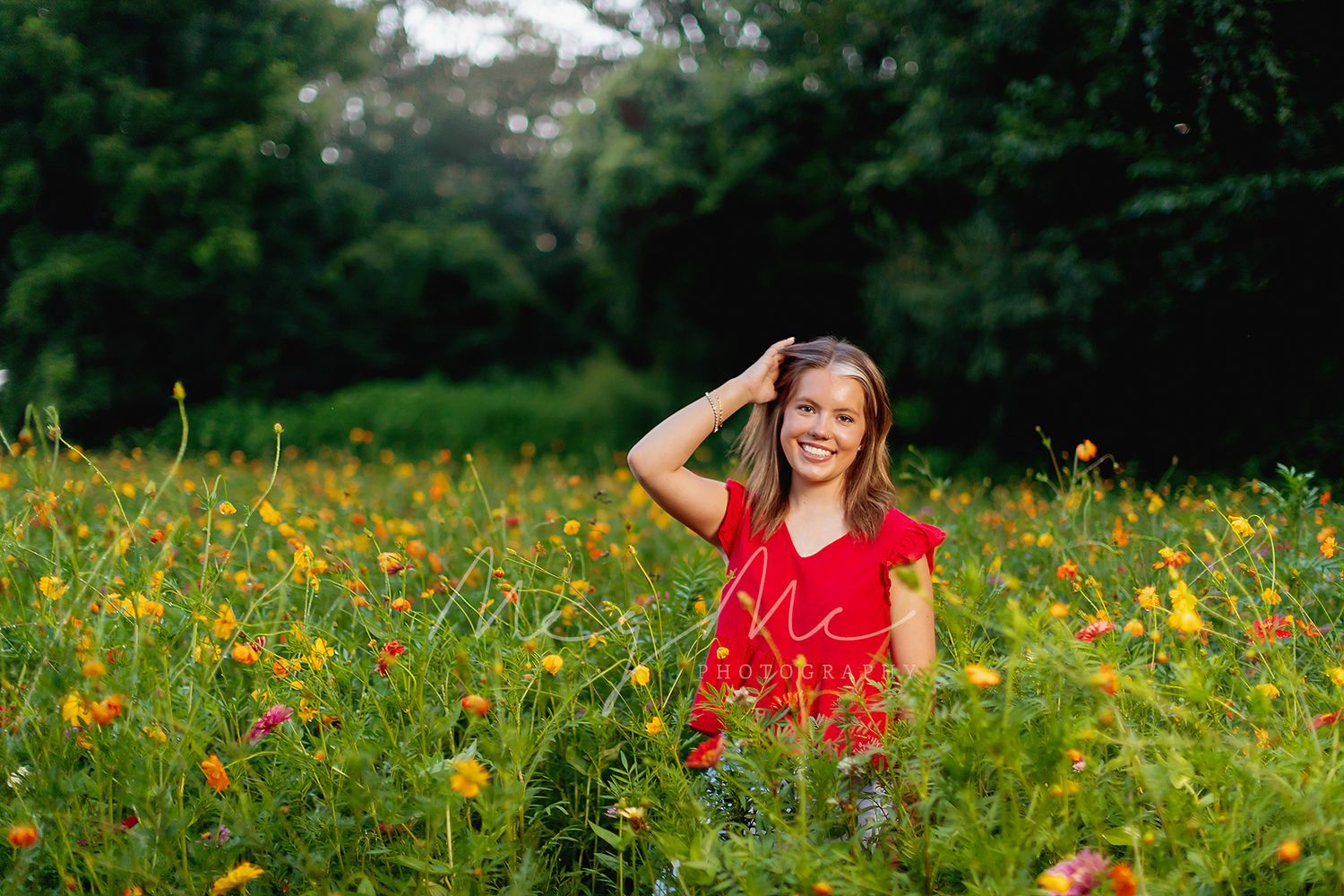 A person in a white dress reclines on grassy hillside with yellow wildflowers on a sunny summer day.