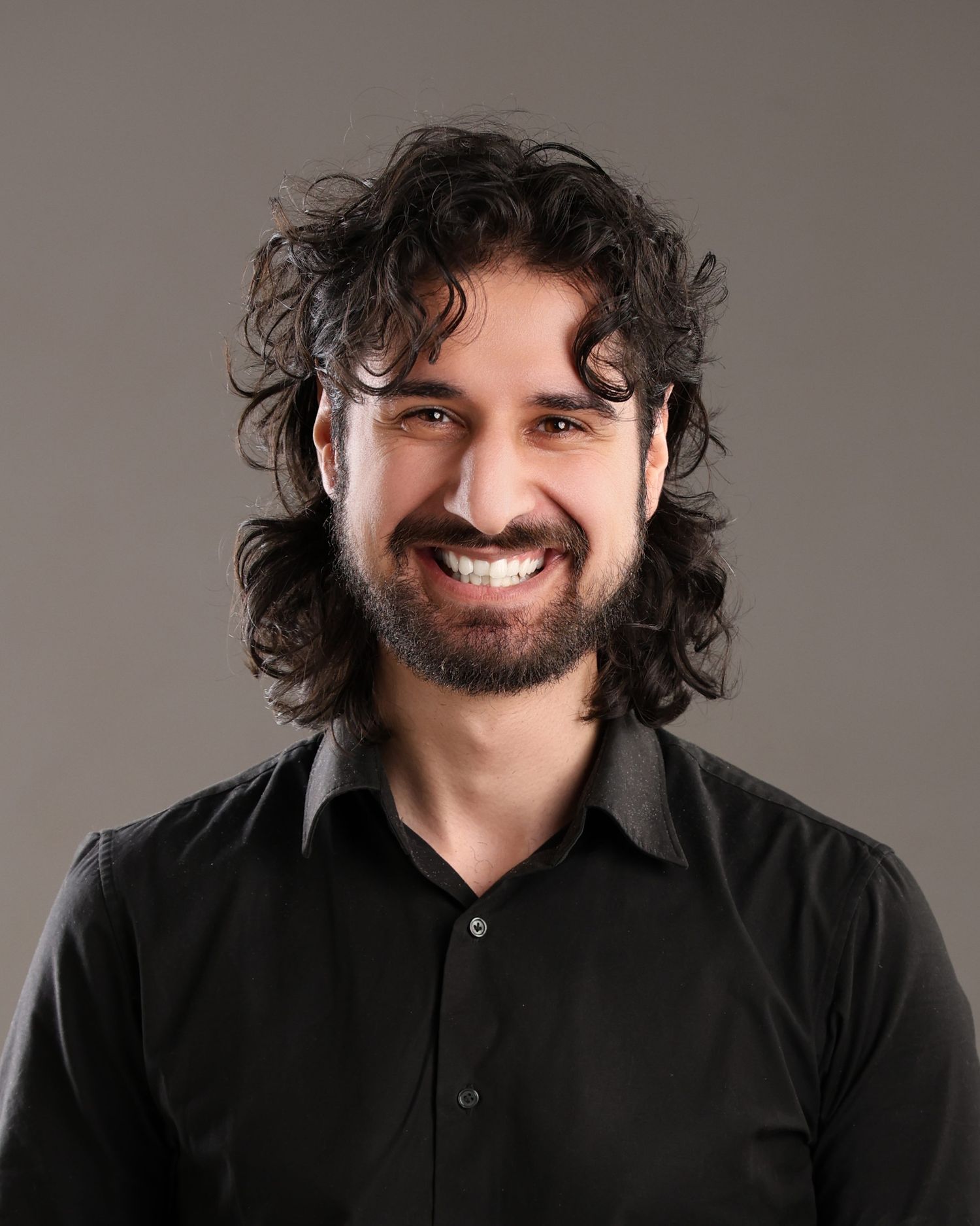 Professional headshot of businessman in pinstripe suit against light background.
