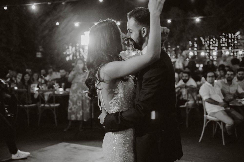Couple shares romantic first dance under twinkling lights at wedding reception.