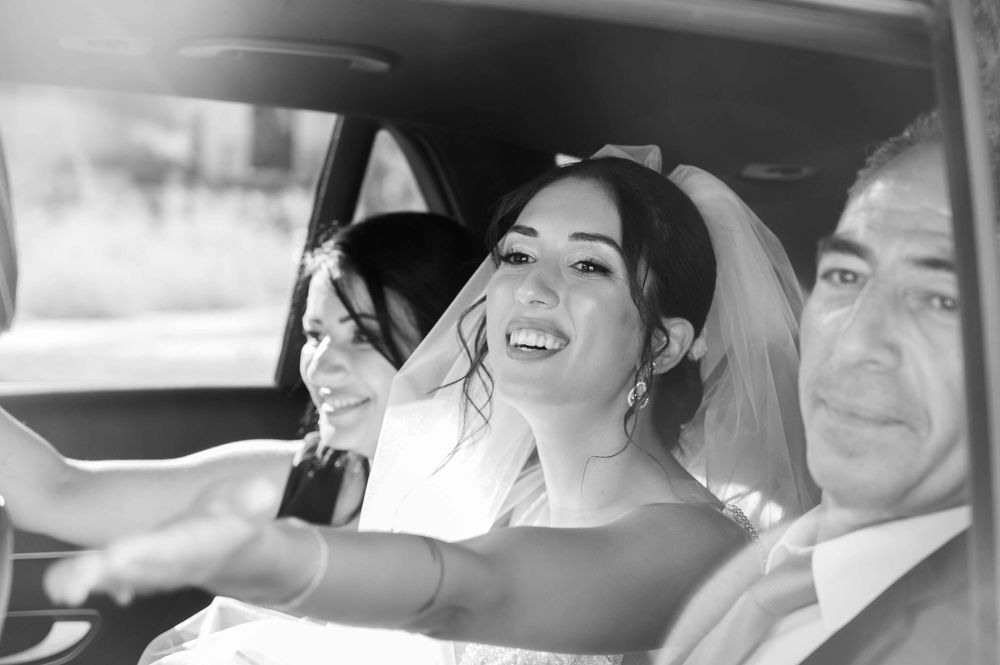 A joyful moment captured in black and white inside a wedding car.