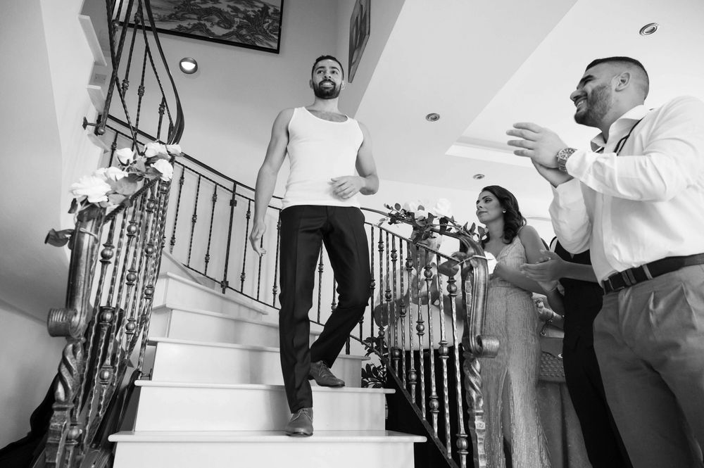 Wedding party descends staircase during preparation moments.