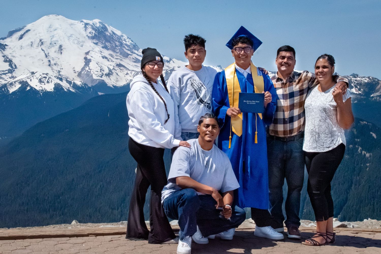 Family photo at the top of Crystal Mountain featuring Class of 2025 graduate and relatives with a stunning mountain view.