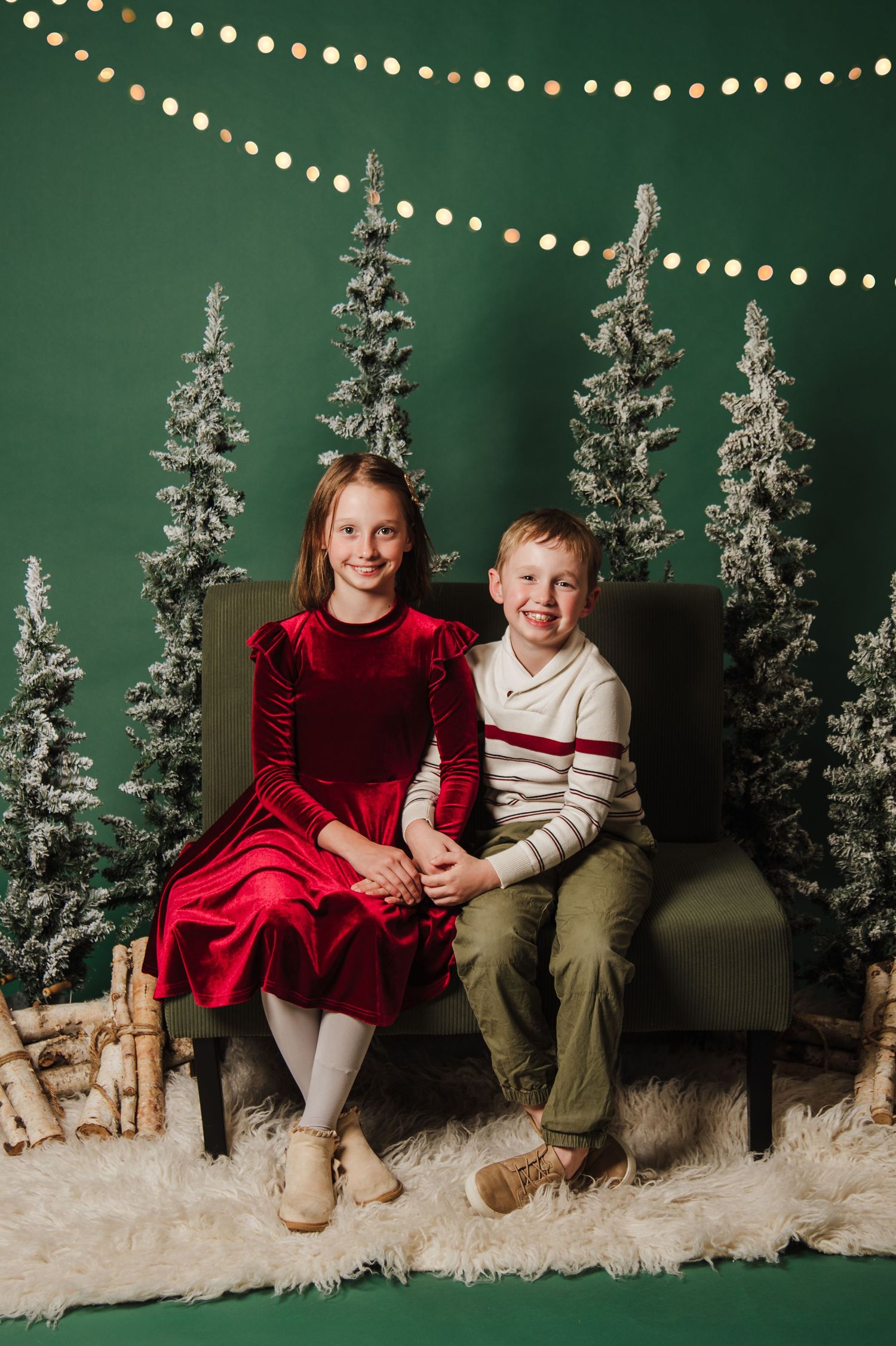 Holiday portrait with snowy trees and string lights creating a festive winter scene.