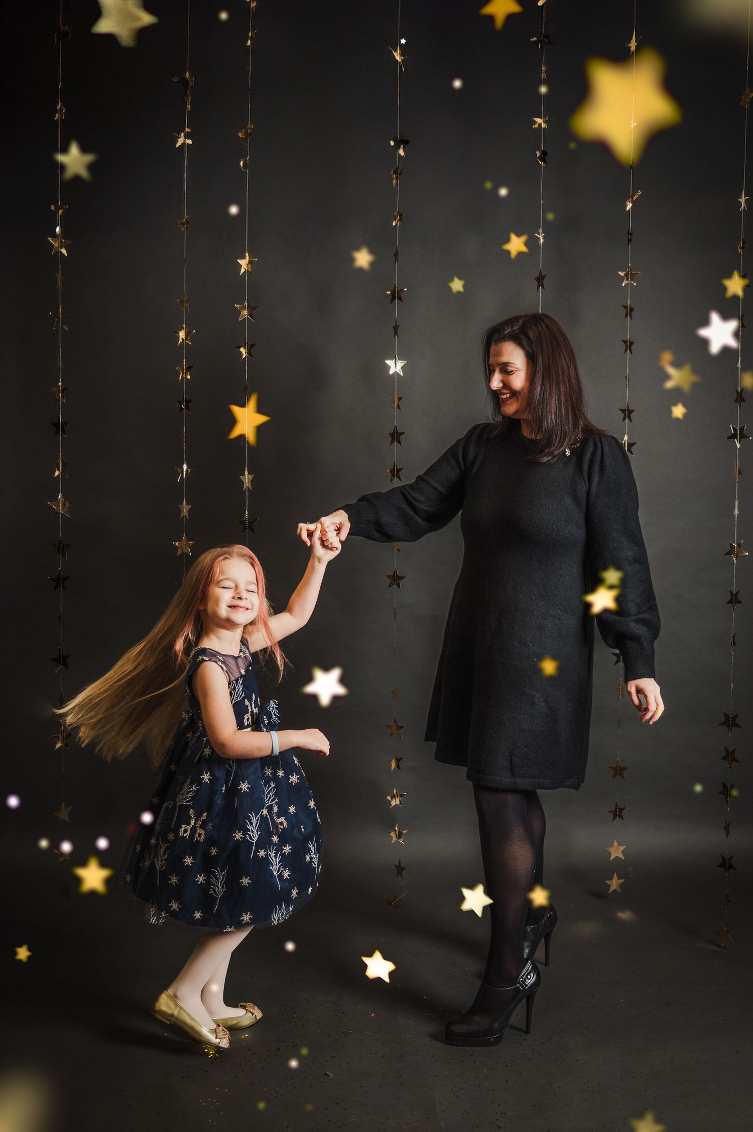 Joyful dancing captured against a backdrop of hanging golden stars and twinkling lights.