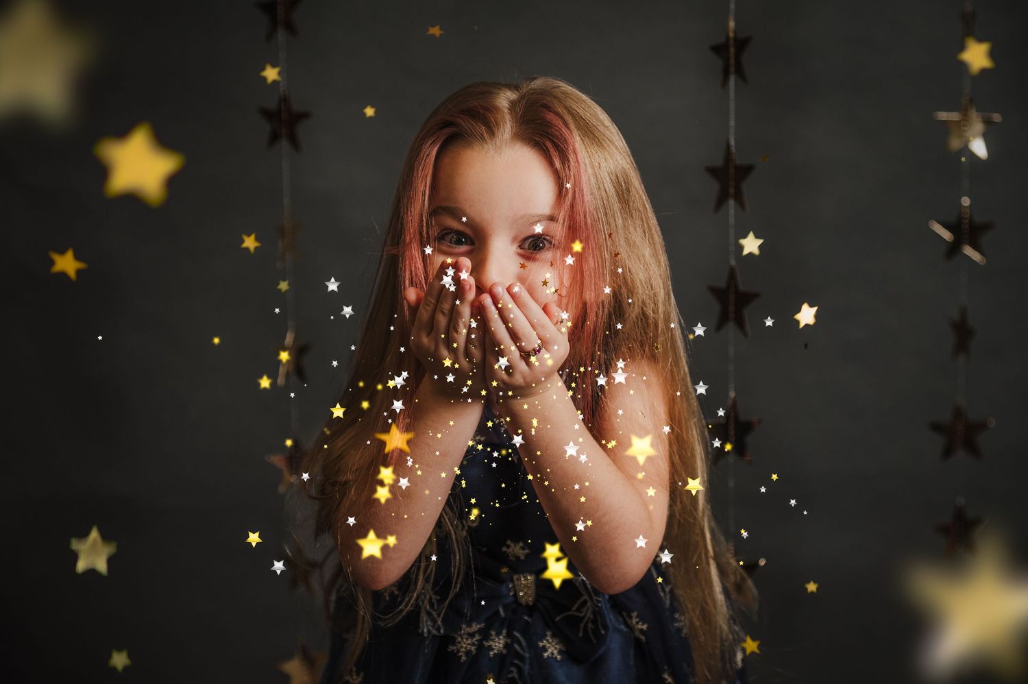 Enchanting portrait with sparkling gold stars and magical lighting effects on dark background.