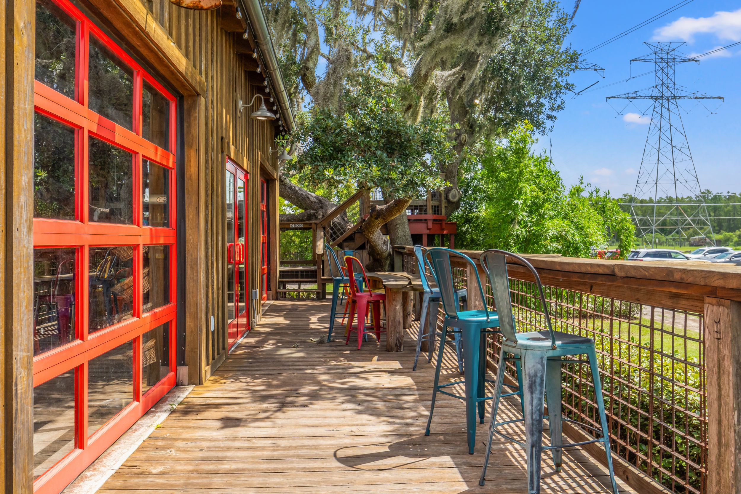 Covered wooden walkway with red trim extending into the distance under blue skies.