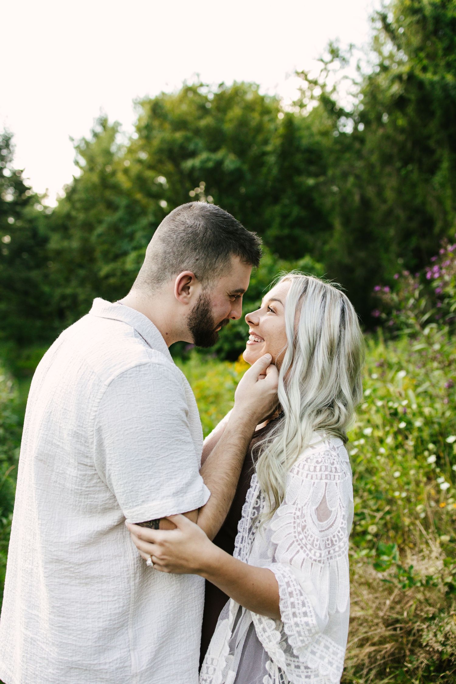 A romantic black and white photo sequence of a couple in wedding attire sharing a tender kiss outdoors.