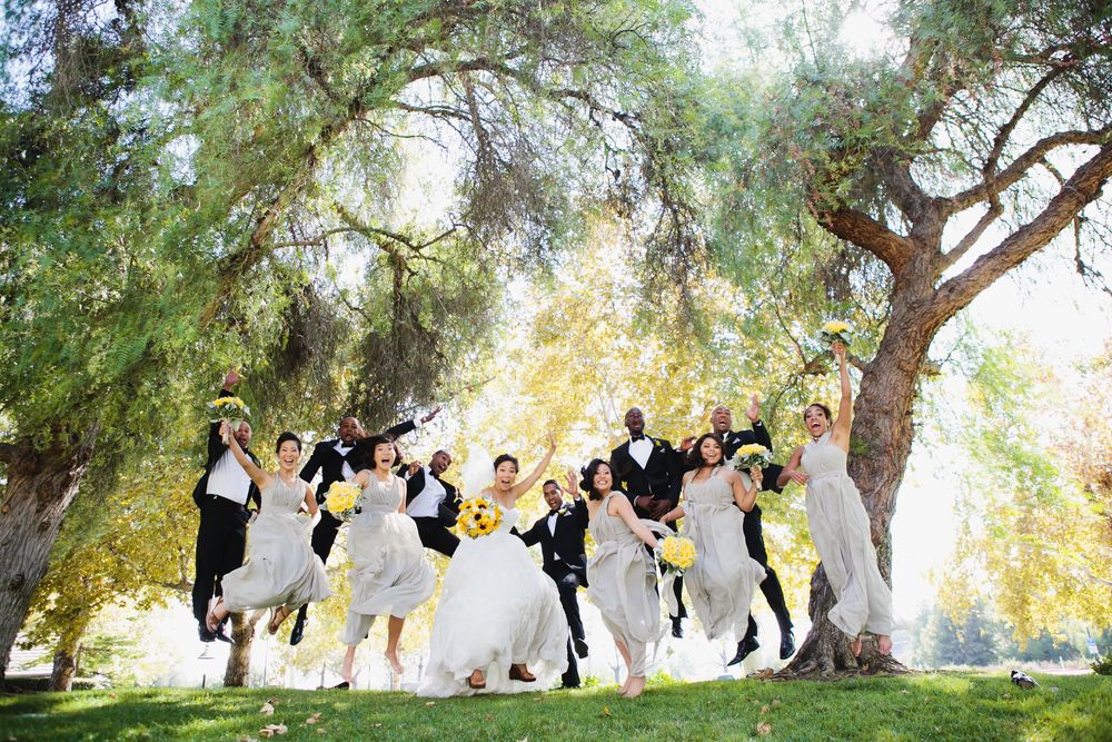 Wedding party poses under trees for creative group photo session at the Summit House in Orange County, CA