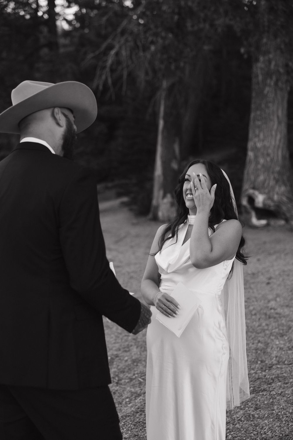A romantic black and white wedding photo series showing tender embraces between a couple in an outdoor setting.
