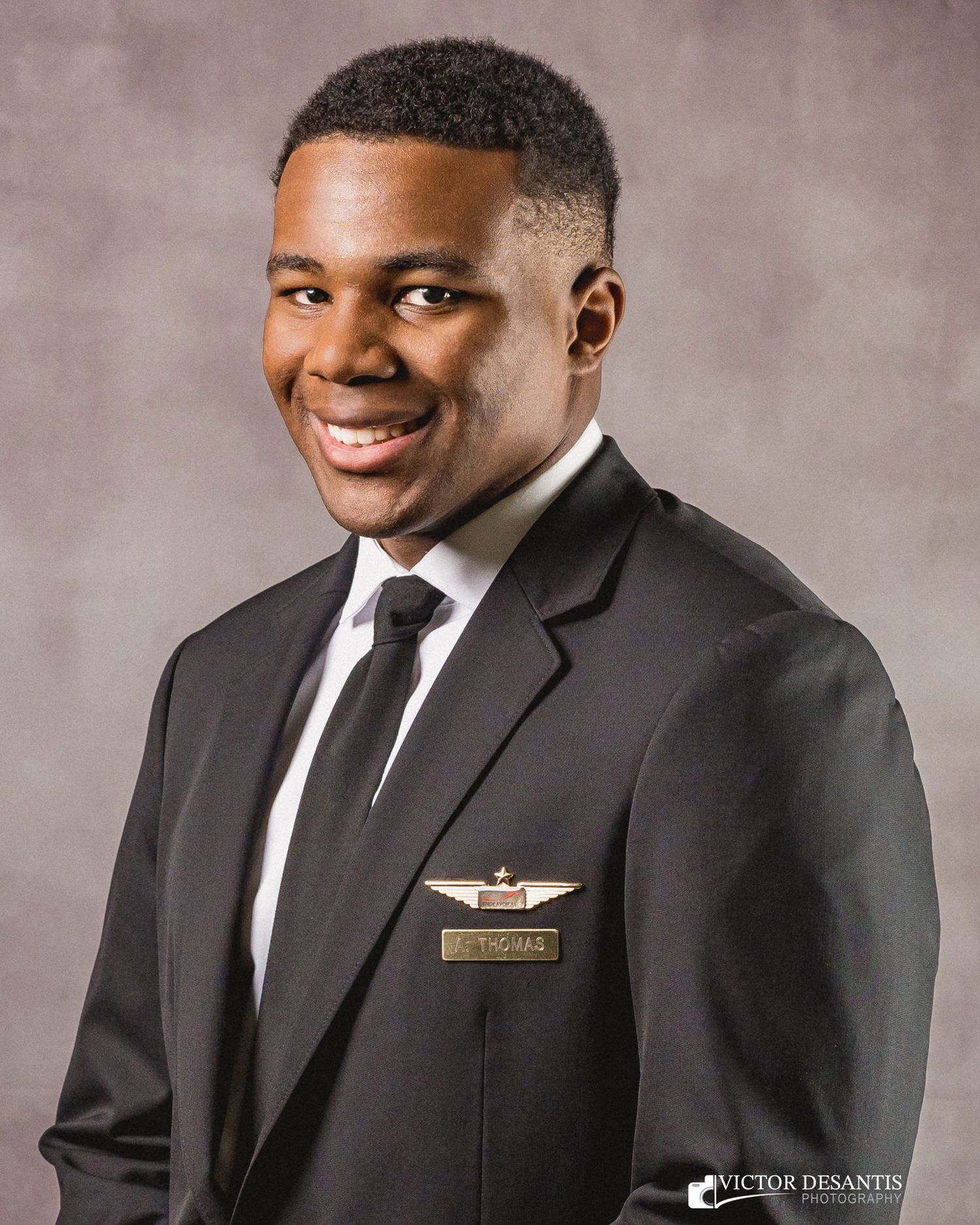 Professional portrait series showing someone in a black suit with white shirt and tie against a textured gray background.