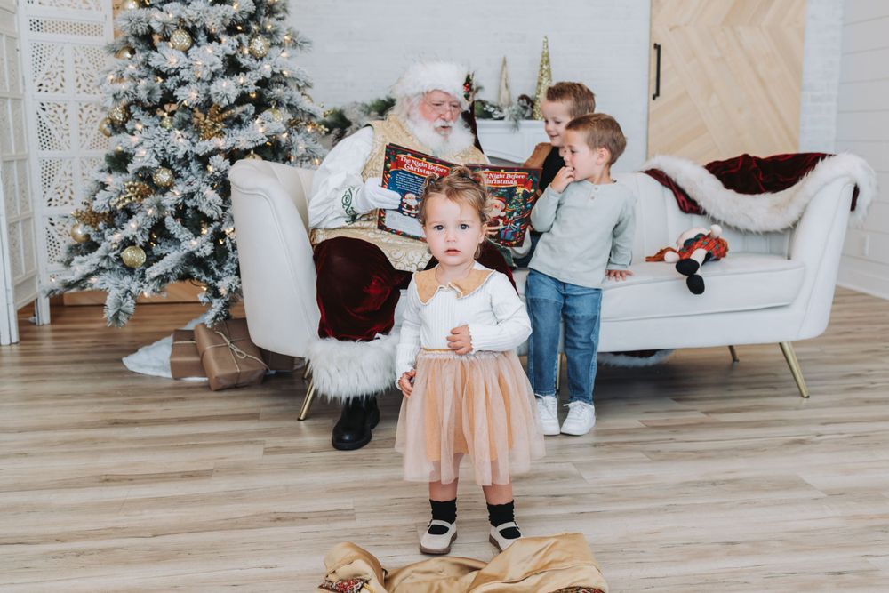 A decorated Christmas tree sits in a bright modern room with light hardwood floors and white walls.