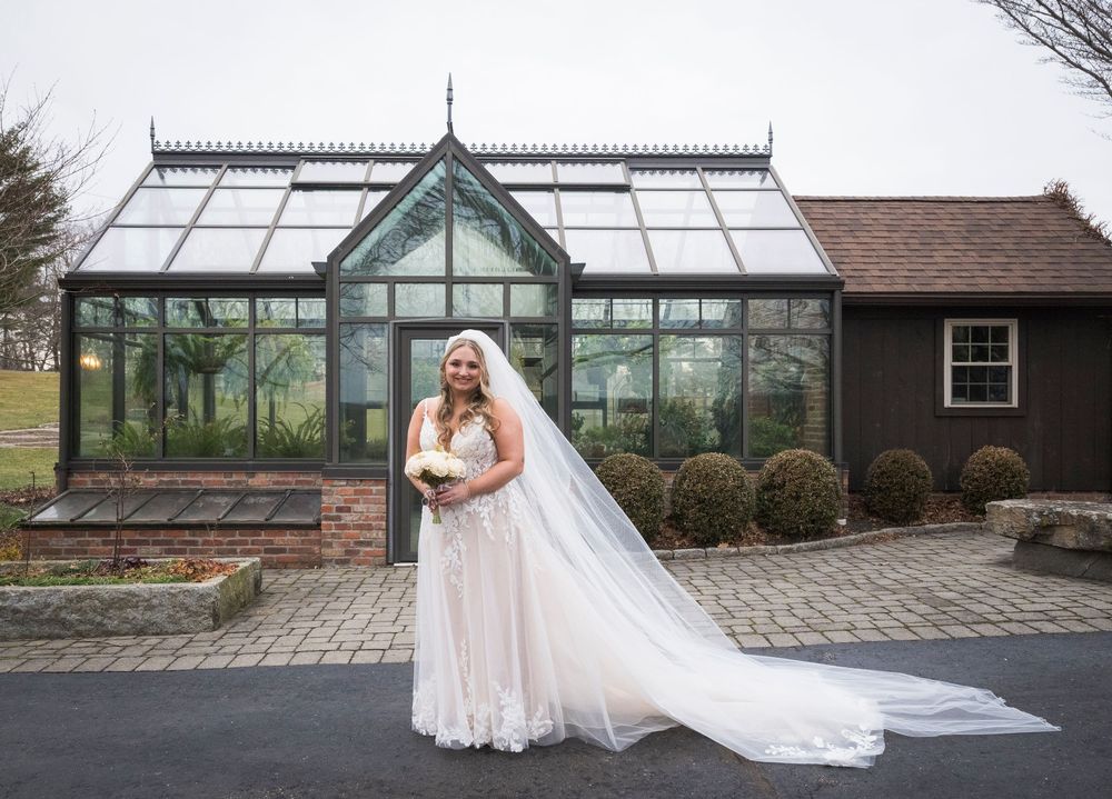 Elegant wedding venue exterior with greenhouse and brick architecture.