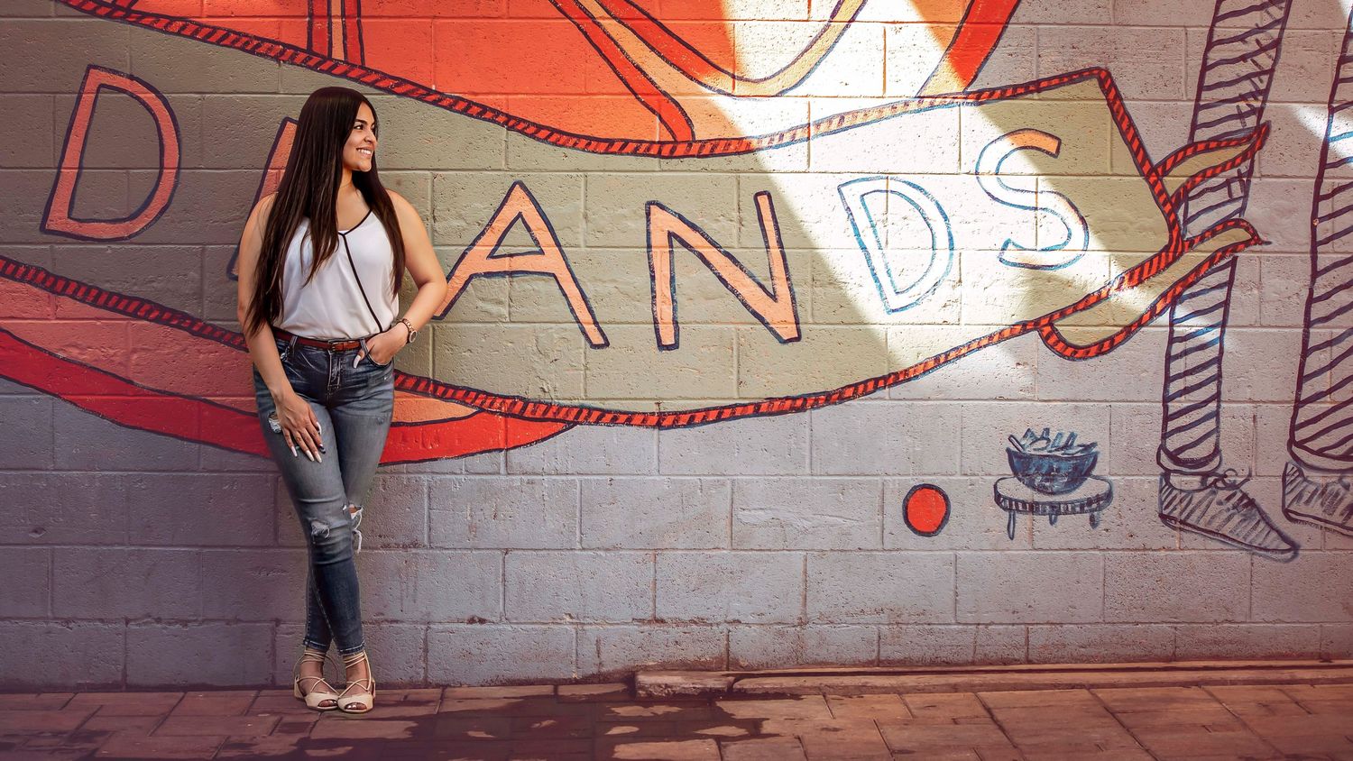 Dynamic panoramic shot featuring graffiti art and street performers against an orange wall.