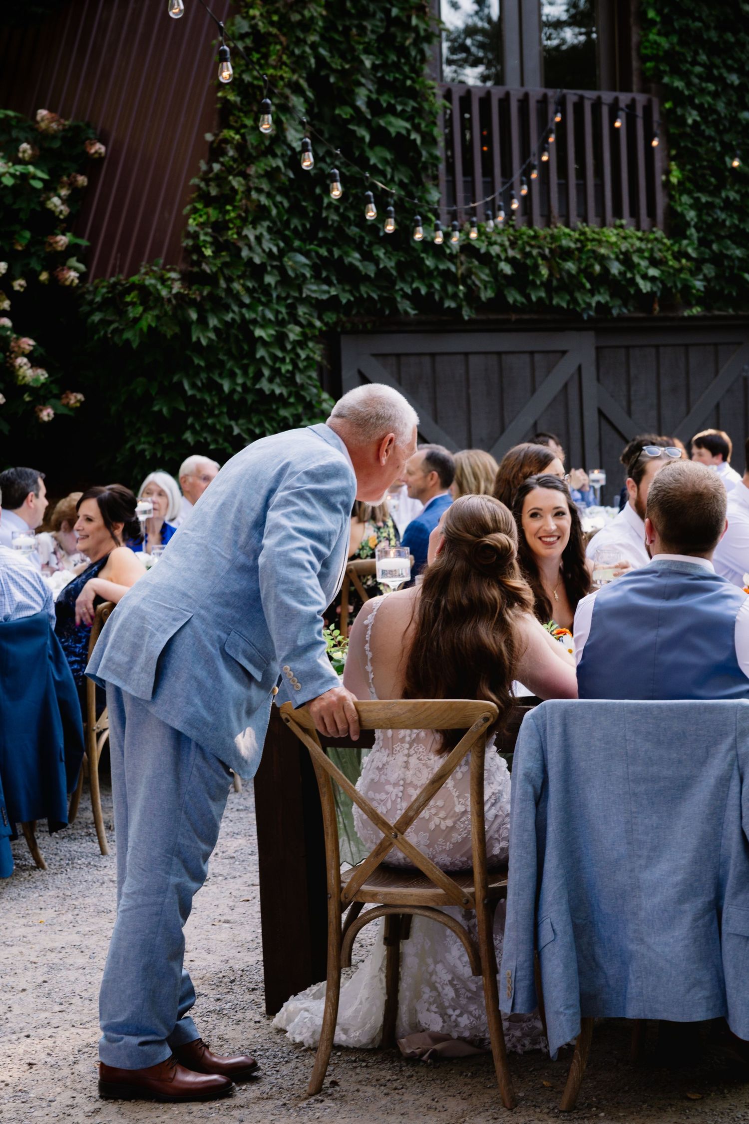 A series of four candid photos showing guests socializing at an outdoor wedding reception with a lush green ivy backdrop.