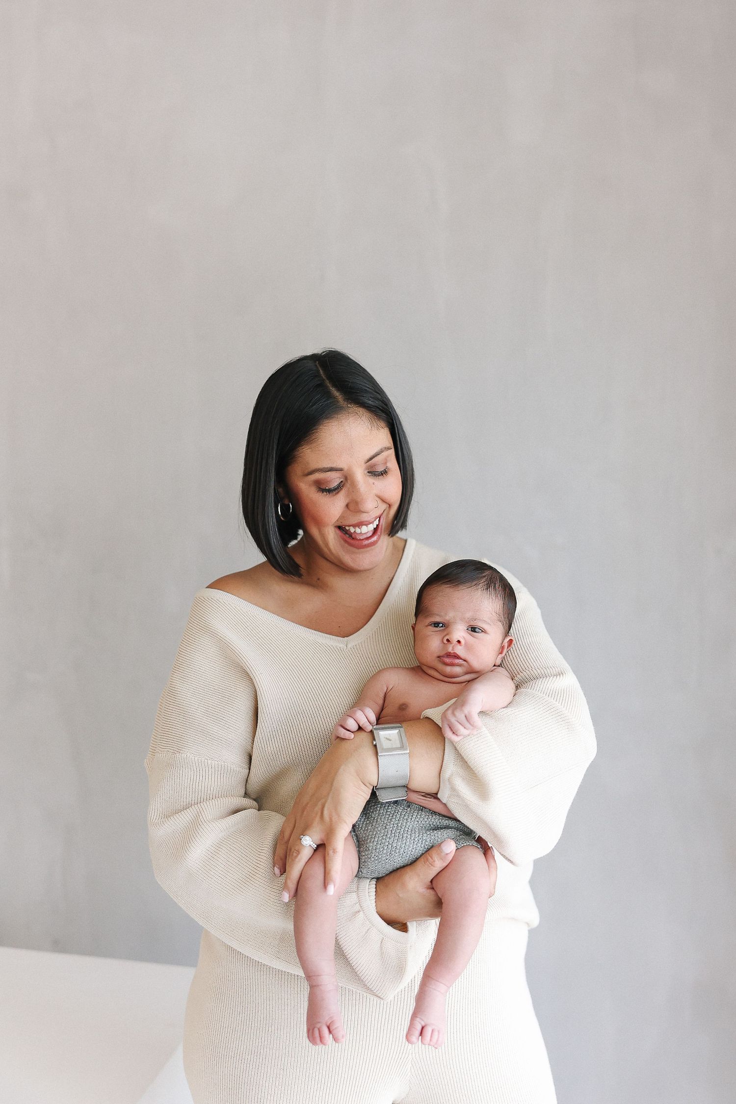 Lifestyle newborn baby portraits with mom and newborn baby in her arms at Spark Studios