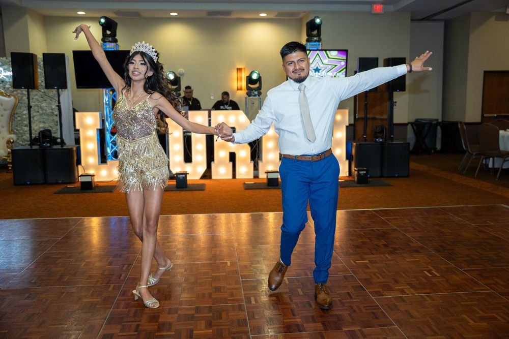 Quince party performs choreographed dance moves on a wooden dance floor.