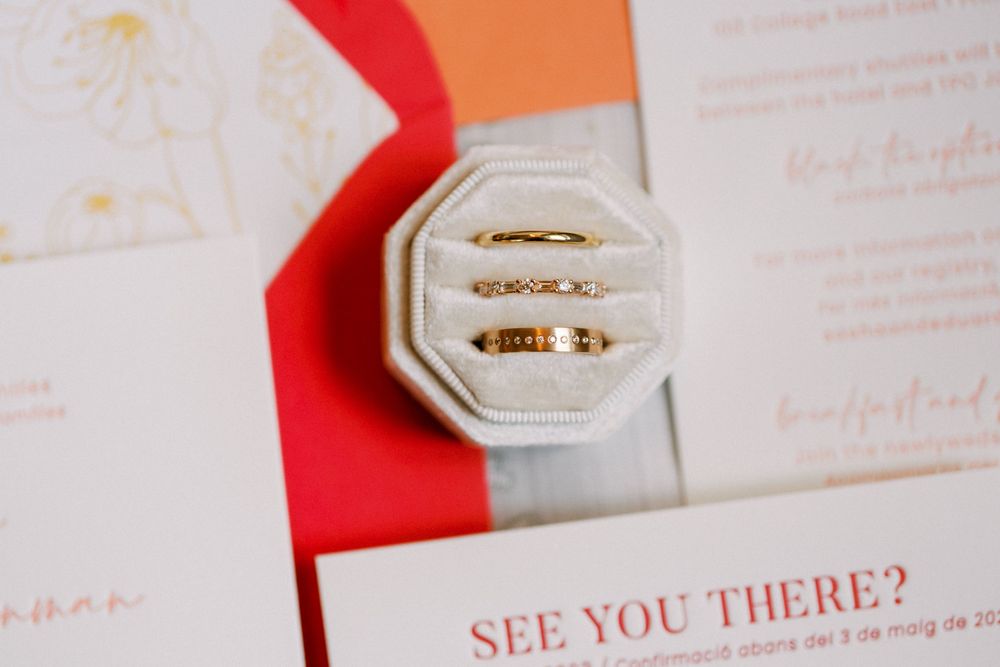 Wedding invitation suite featuring elegant floral designs and red accents arranged on a white surface.