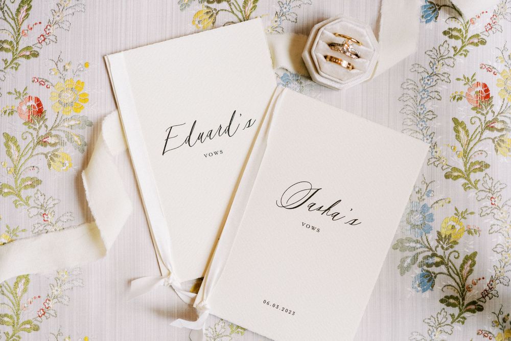 Elegant wedding stationery with calligraphy and delicate details laid out on a white background.
