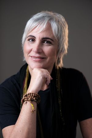 Artistic portrait series showing a person with silver hair in black clothing against a dark background.