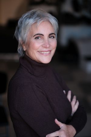 Cozy portrait series in brown turtleneck sweater with silver hair against dark background.