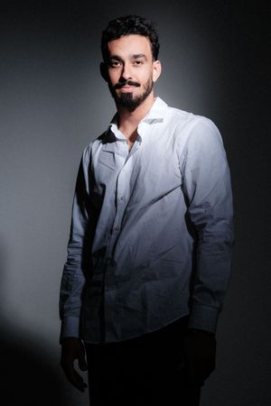 Stylish portrait series of man in white suit jacket with dramatic lighting.