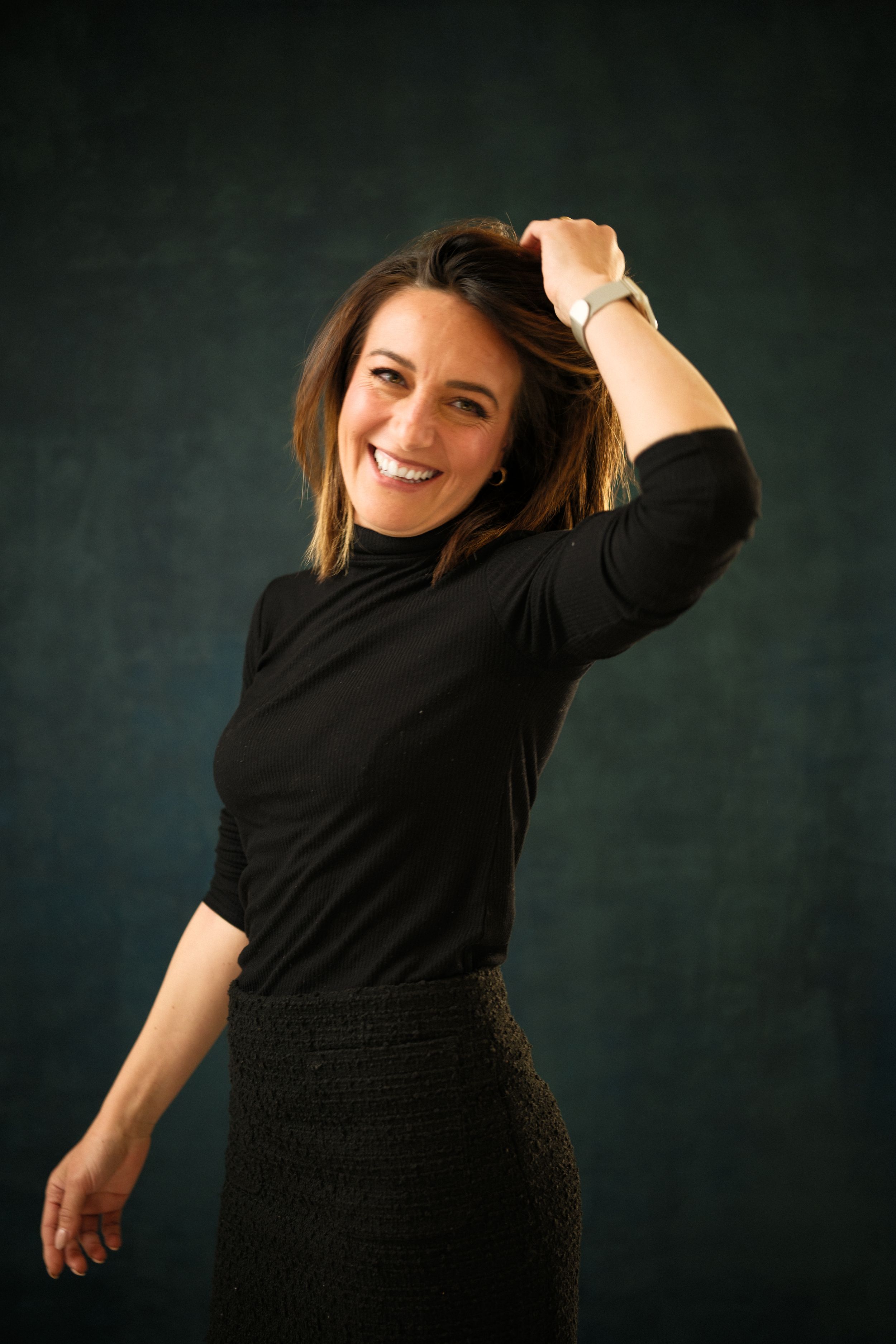 Dynamic portrait series in black attire against a dark background showing playful movement.