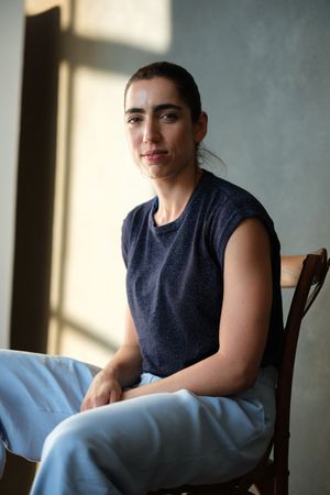 Casual portrait series featuring someone in a navy sleeveless top and light blue pants.